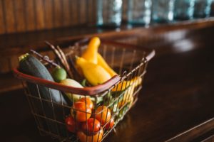 Einkaufskorb auf Tisch gefüllt mit Obst und Gemüse
