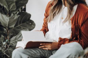 Frau sitzt mit Buch in der Hand